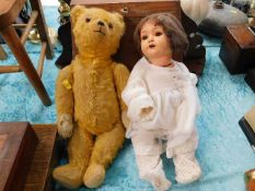 A vintage teddy bear with doll