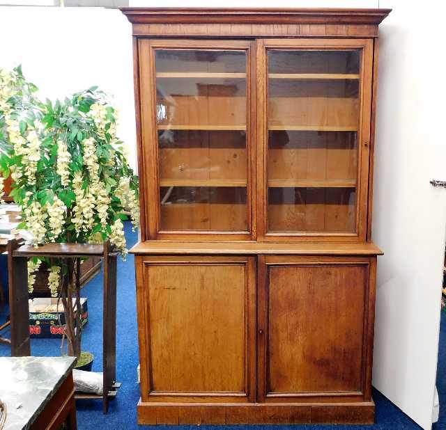 An antique oak bookcase with glazed sliding doors