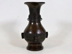 An early style Chinese bronze vase with a pair of taotie mask handles lacking rings decorated with a