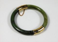 An antique nephrite jade bangle with metal fitting