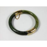 An antique nephrite jade bangle with metal fitting