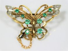 A 9ct gold butterfly brooch set with diamond & eme