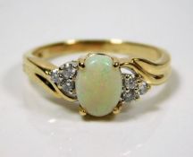 A 9ct gold opal ring set with three diamonds on ea