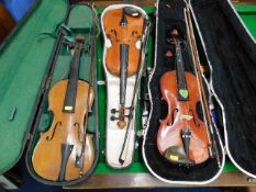 Three vintage violins as found with three bows