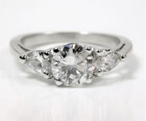A platinum set with a round cut centre stone of 1.32cts of F colour & flanked by two pear shaped dia