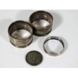 Two silver napkin rings, a small silver scarf ring