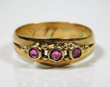A yellow metal antique ring set with three rubies