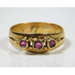 A yellow metal antique ring set with three rubies