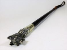 A braided leather riding crop with detailed white metal fox design marked SWAINE to white metal ferr