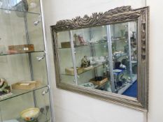 A modern carved silver coloured frame wall mirror