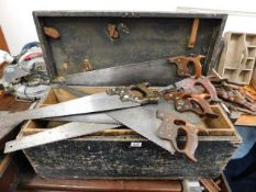 A carpentry box with various hand saws including D