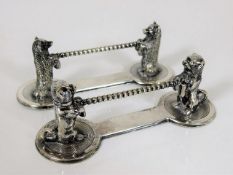 Two white metal novelty knife rests featuring dogs