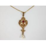 An antique gold pendant set with ruby & pearl with