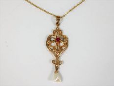 An antique gold pendant set with ruby & pearl with