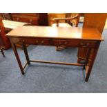 A mahogany console table with brass handles