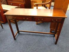 A mahogany console table with brass handles