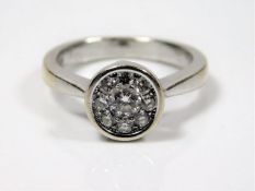 An 18ct white gold diamond daisy ring, centre ston