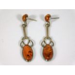 A pair of white metal art nouveau style amber drop