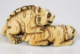 A c.1900 Japanese carved ivory netsuke of two tige