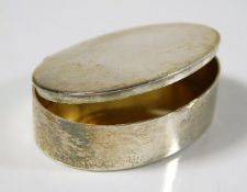 A small silver pill box with gilt lining