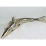 A white metal articulated fish with blue stone eye