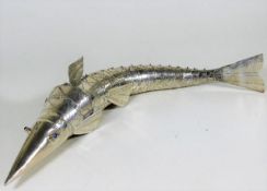 A white metal articulated fish with blue stone eye