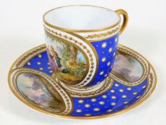 A 19thC. French Sevres style porcelain cup & saucer with fine hand painted decorative panels, indist