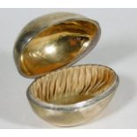 A silver silk lined egg shaped box with gilt inter