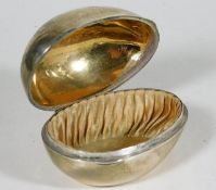 A silver silk lined egg shaped box with gilt inter
