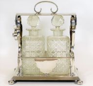 A silver plated tantalus with two cut glass decant