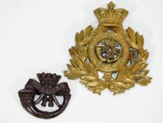 A brass DCLI cap badge & one other