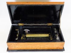 A 19thC. music box with inlaid oak case
