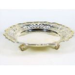 A footed silver dish with reticulated edge
