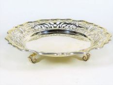 A footed silver dish with reticulated edge