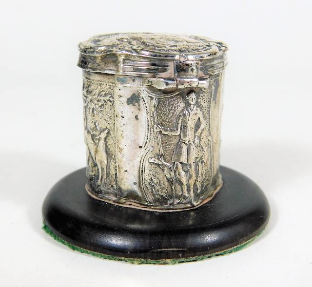 A small white metal peppermint box with embossed figurative decor mounted