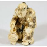 A c.1900 Japanese carved ivory netsuke of man with