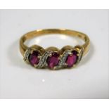 A 9ct gold ring set with pink stones & small diamo