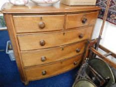 A Victorian bow fronted oak chest of drawers, warping to one side panel