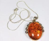 A silver mounted amber pendant & chain