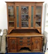 A c.1900 arts & crafts style glazed oak dresser with three drawers, pet space & two cupboards to bas