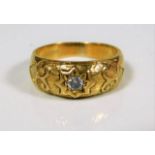 An 18ct gold ring set with diamond on carved shank
