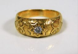 An 18ct gold ring set with diamond on carved shank