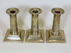 Three matching silver Corinthian column candlestic