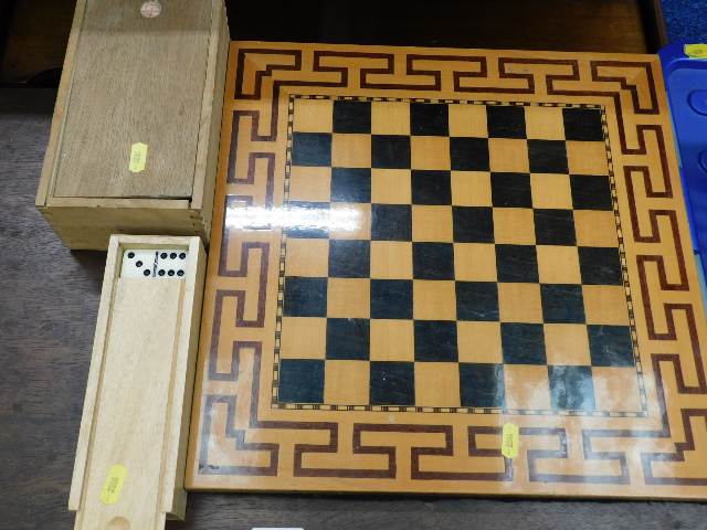 A modern chess board with chess pieces & a dominoe