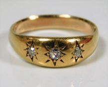 An antique yellow metal ring set with three diamon