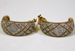 A pair of 9ct gold half hoop earrings set with dia