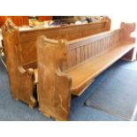 Two oak church pews, each with decorative carved e