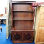 A mahogany style backlit shelf unit with cupboards