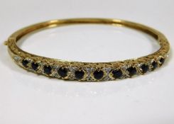 A 9ct gold bangle set with diamonds & sapphires 10