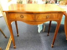 An antique mahogany serpentine front hall table wi